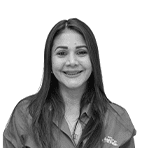 Adriana Colmenarez, Coca-Cola team member, smiling with long straight hair, wearing the 80th anniversary company shirt, on a white background.