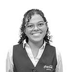 Hadassa Poulo in Coca-Cola Curacao vest, smiling confidently and representing service and warmth.